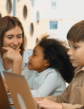 Teacher interacting with students who are using laptops