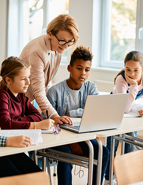 Teacher with students using a laptop