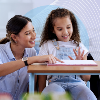 An educator helps a young student read and write. Links to WestEd’s literacy services, research, and policy work.